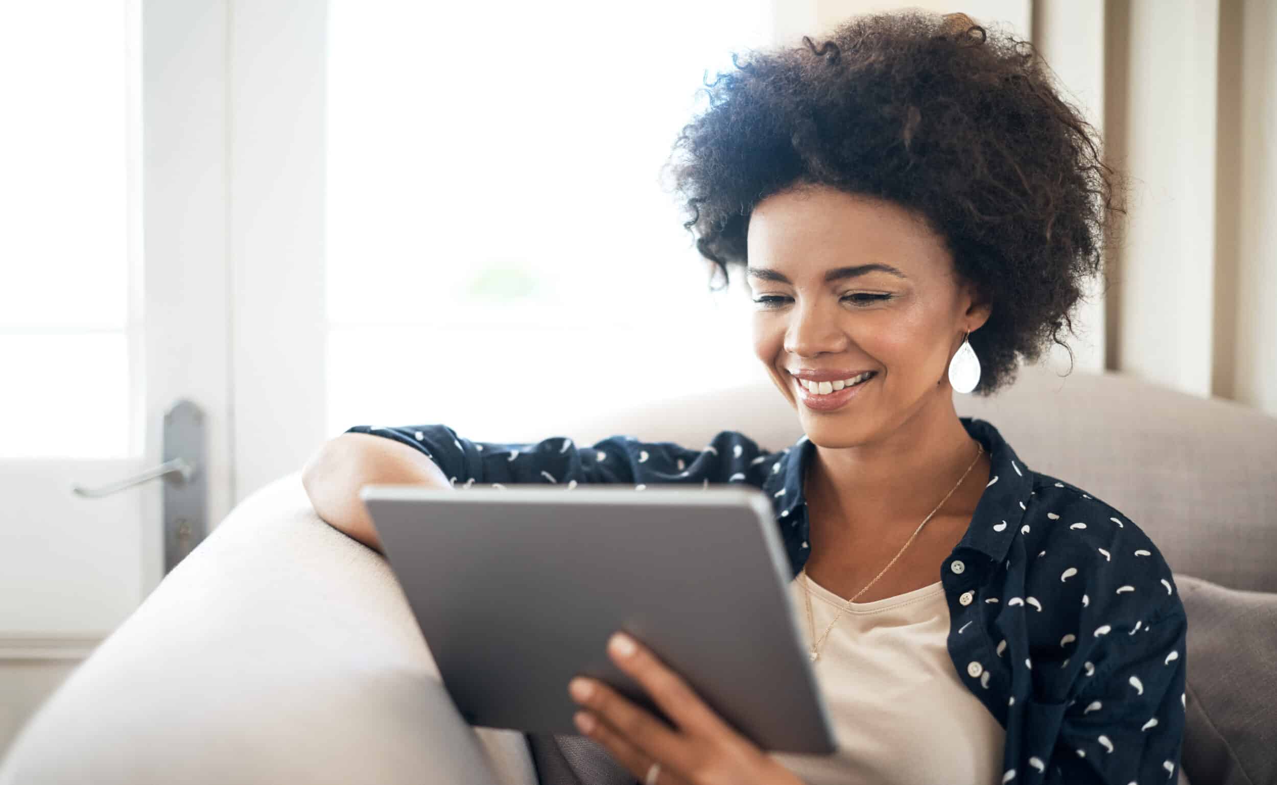 Shot of a young woman relaxing at home with her digital tablet