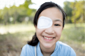 Asian child girl cover with blindfolded bandaged eye after surgery