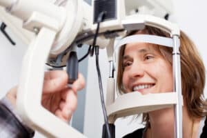 doctor examining womans eyes with a measurement machine