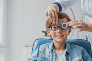 Vision test for elementary school boy to maintain good eye health and determine prescription lenses.
