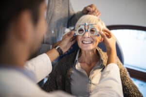 Older woman undergoing vision testing as part of an evaluation for cataract surgery.