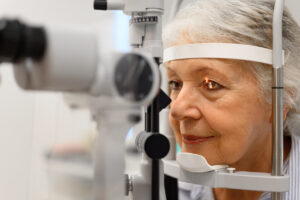 Older patient undergoing a slit-lamp eye examination to assess retinal health.