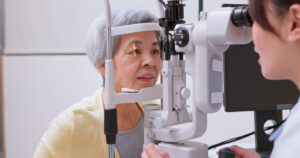 Older patient undergoing a slit-lamp eye exam to evaluate cataracts and changes in vision.